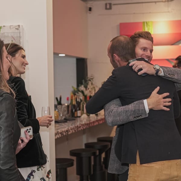 People hugging in Carousel Fine Art's Miami gallery space during the Grand Opening.
