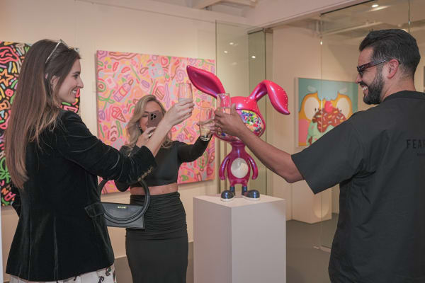 People cheering drinks Carousel Fine Art's Miami gallery space during the Grand Opening.