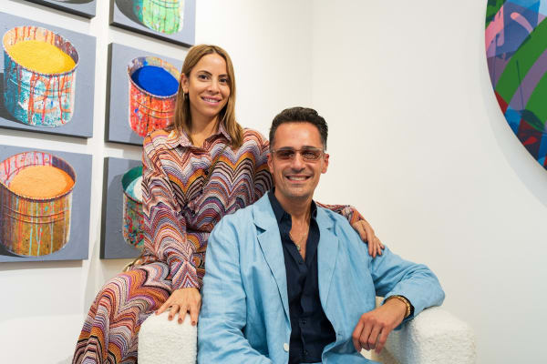 People posing on chair in Carousel Fine Art's Miami gallery space during the Grand Opening.
