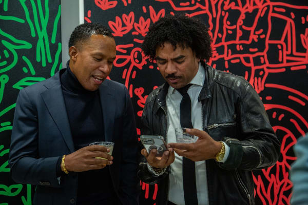 People in front of paintings displayed at Carousel Fine Art's new gallery space in Buckhead Village, Atlanta during an event for their grand opening.