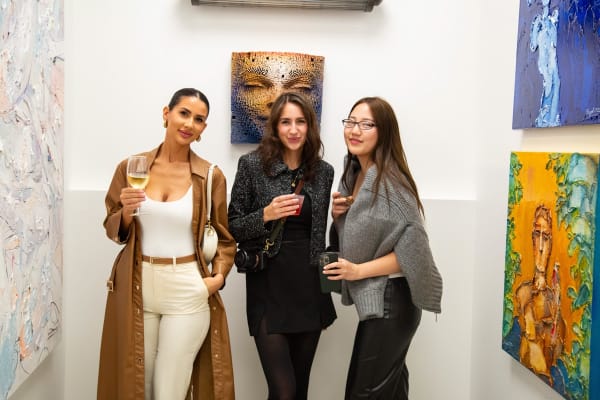 Women posing in front of a sculpture displayed at Carousel Fine Art's new gallery space in Buckhead Village, Atlanta during an event for their grand opening.