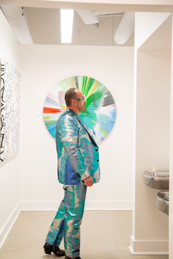 Man staring at paintings displayed in Carousel Fine Art's new gallery space in Buckhead Village, Atlanta during an event for their grand opening.