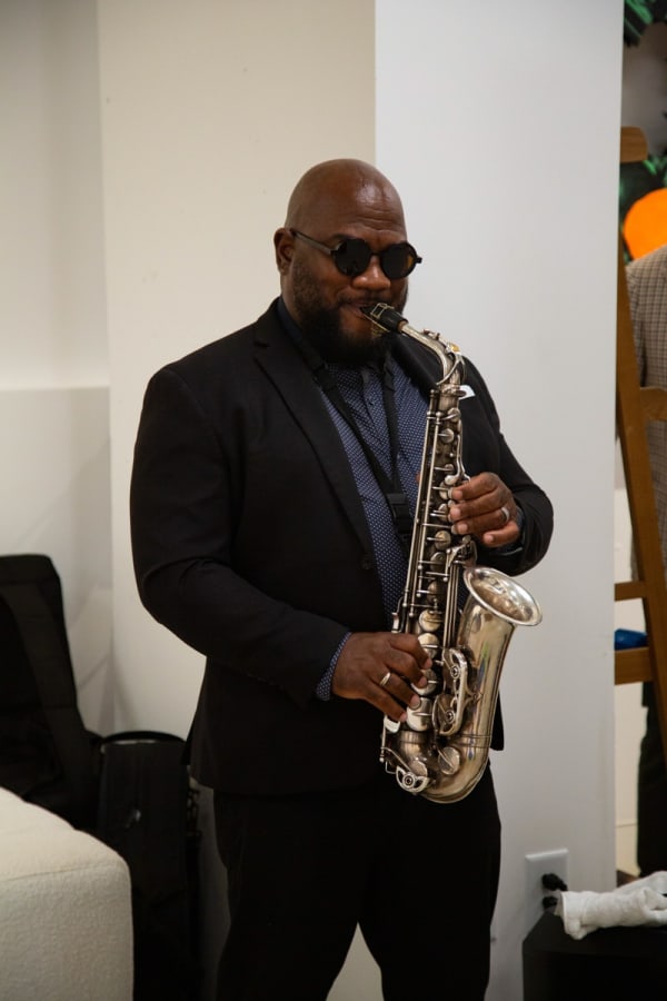 Man playing saxophone Carousel Fine Art's new gallery space in Buckhead Village, Atlanta during an event for their grand opening.