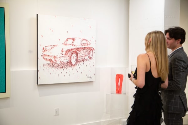 Woman staring at paintings displayed at Carousel Fine Art's new gallery space in Buckhead Village, Atlanta during an event for their grand opening.