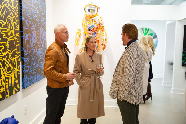 People talking at Carousel Fine Art's new gallery space in Buckhead Village, Atlanta during an event for their grand opening.