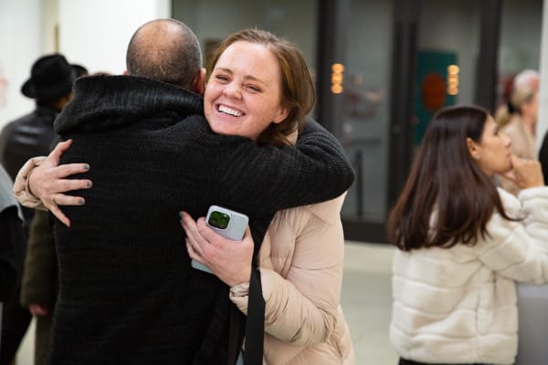 People hugging at Carousel Fine Art's new gallery space in Buckhead Village, Atlanta during an event for their grand opening.