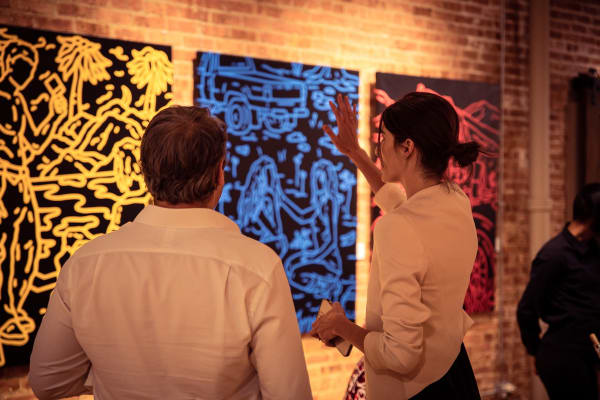 People in Carousel Fine Art's Chicago gallery space staring at paintings displayed.