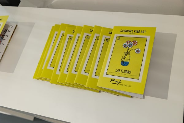 Cayla Birk's exhibition booklets displayed on table in Carousel Fine Art's Miami location for the Cayla Birk exhibition, "It's in the Cards."