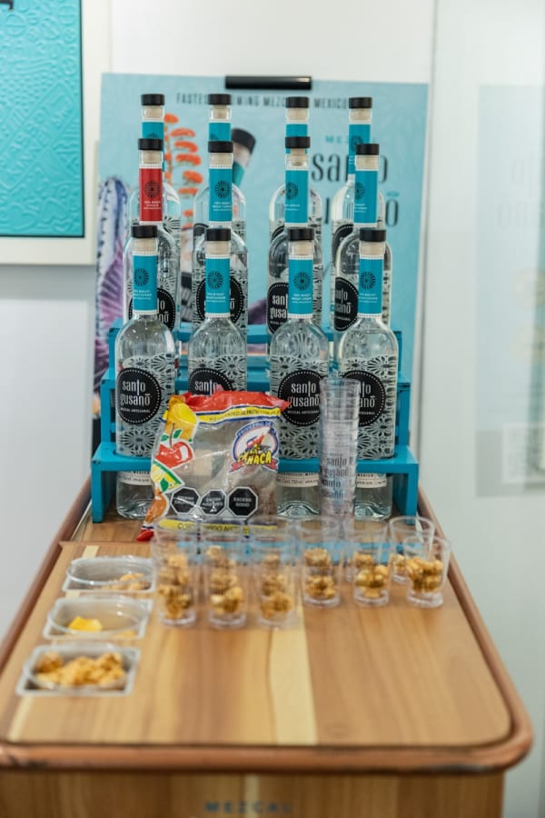 Tequila bottle and shots displayed in Carousel Fine Art's Miami location for the Cayla Birk exhibition, "It's in the Cards."