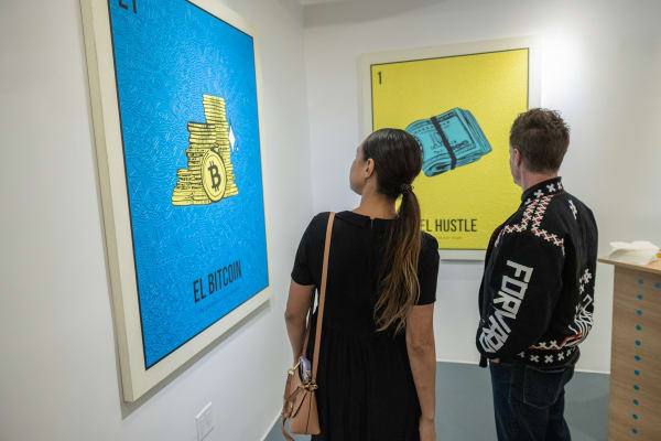 People staring at Cayla Birk's artworks displayed in Carousel Fine Art's Miami location for the Cayla Birk exhibition, "It's in the Cards."