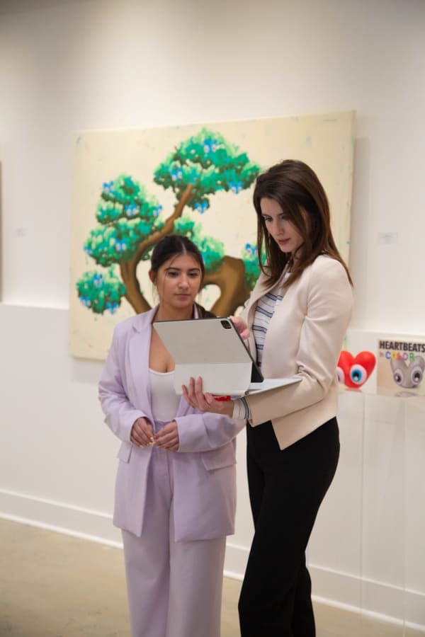 Women in front of paintings created by John Westbay displayed in Carousel Fine Art's Atlanta gallery space during the spotlight exhibition for John Westbay titled "Love, Outside the Lines."