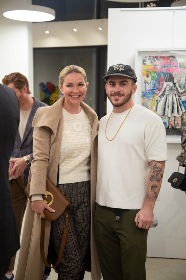 Woman posing with artist John Westbay Carousel Fine Art's Atlanta gallery space during the spotlight exhibition for John Westbay titled "Love, Outside the Lines."
