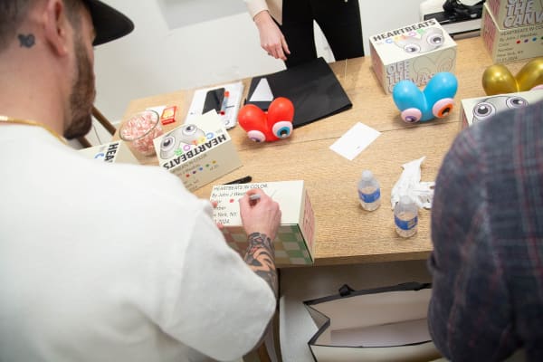 Artist John Westbay signing box during the spotlight exhibition for John Westbay titled "Love, Outside the Lines."