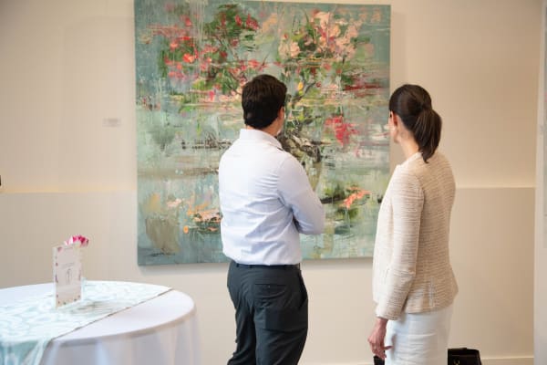 People staring at painting by Eric Alfaro displayed in Carousel Fine Art's Buckhead Village location during the exhibition "Spring Reverie."