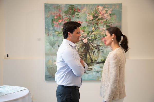People standing in front of a painting by Eric Alfaro displayed in Carousel Fine Art's Buckhead Village location during the exhibition "Spring Reverie."