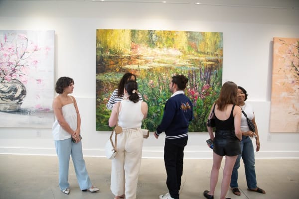 People in front of paintings by Eric Alfaro displayed in Carousel Fine Art's Buckhead Village location during the exhibition "Spring Reverie."