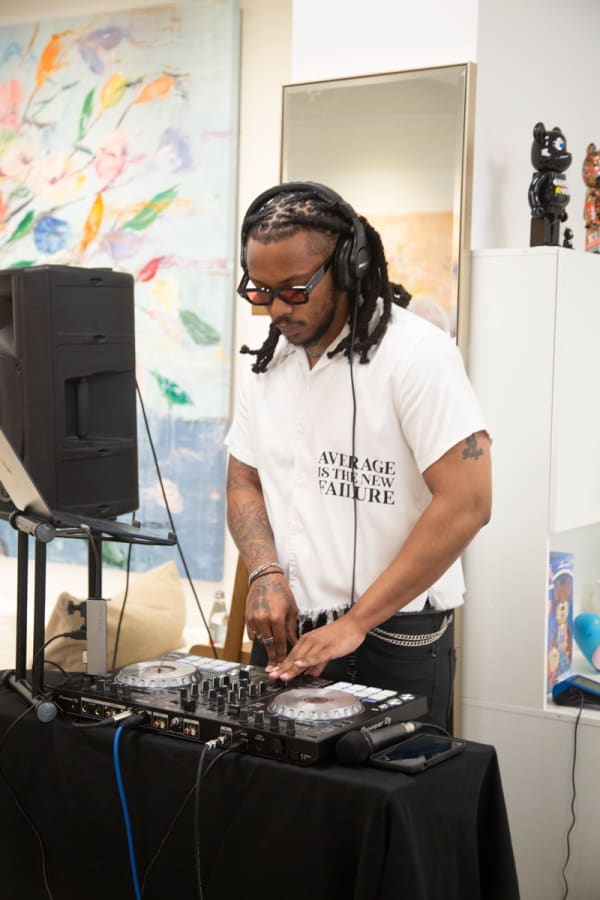 DJ playing music in Carousel Fine Art's Buckhead Village location during the Eric Alfaro exhibition "Spring Reverie."