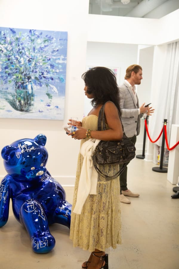 People staring at Eric Alfaro's paintings displayed in Carousel Fine Art's Buckhead Village location during the Eric Alfaro exhibition "Spring Reverie."