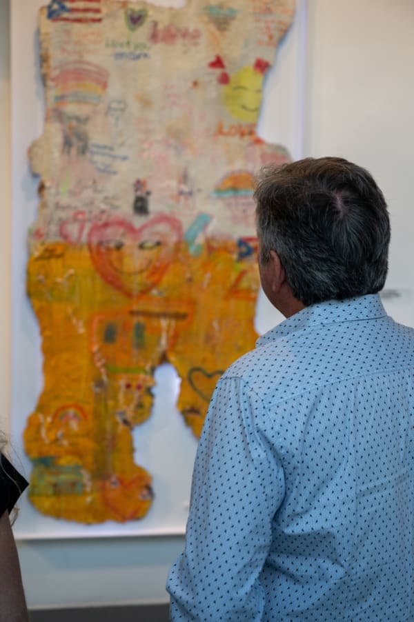 Man staring at artwork by Justin Garcia in Carousel Fine Art's Miami gallery space