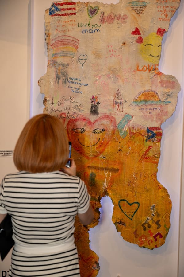 Woman staring at painting by Justin Garcia displayed at Carousel Fine Art's Miami gallery space for the exhibition, "If These Walls Could Talk."