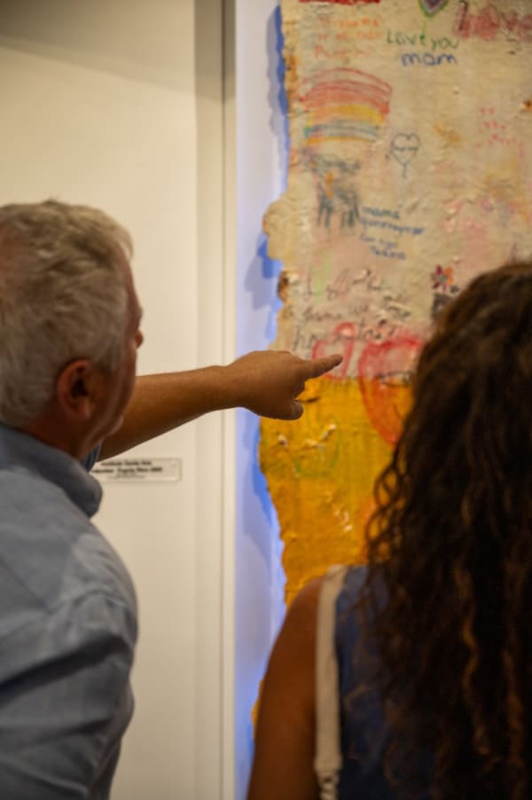 People pointing at painting by Justin Garcia displayed in Carousel Fine Art's Miami gallery space for the exhibition, "If These Walls Could Talk."