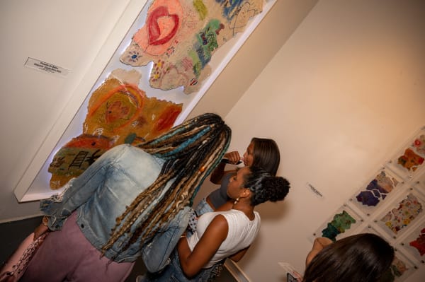 People staring at painting displayed by Justin Garcia at Carousel Fine Art's Miami gallery space for the exhibition, "If These Walls Could Talk."