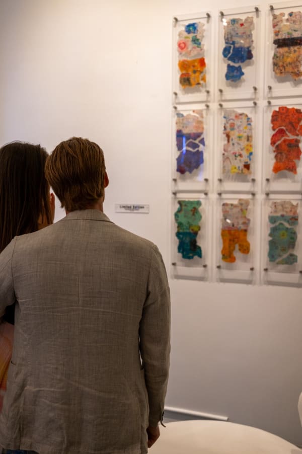 People staring at paintings ini Carousel Fine Art's Miami gallery space for the exhibition, "If These Walls Could Talk."