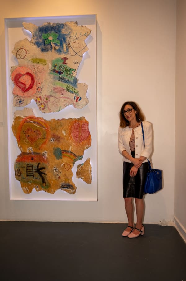 Woman posing next to painting displayed at Carousel Fine Art's Miami gallery space for the exhibition, "If These Walls Could Talk."