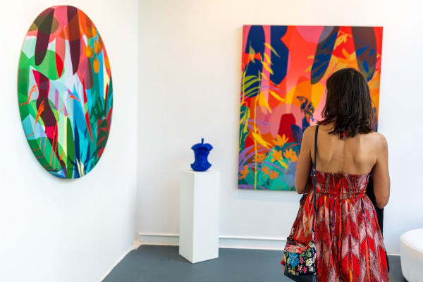 Woman inside Carousel Fine Art's Miami gallery space during Neill Wright's exhibition "Where the Light Gets In."