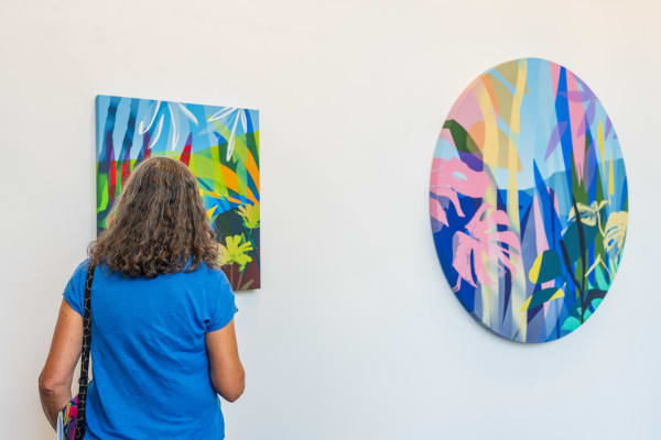 Woman looking at painting by Neill Wright displayed inside Carousel Fine Art's Miami gallery space during Neill Wright's exhibition "Where the Light Gets In."
