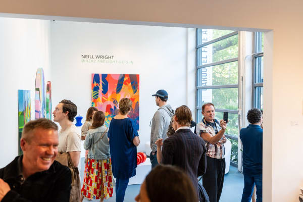 People inside Carousel Fine Art's Miami gallery space during Neill Wright's exhibition "Where the Light Gets In."