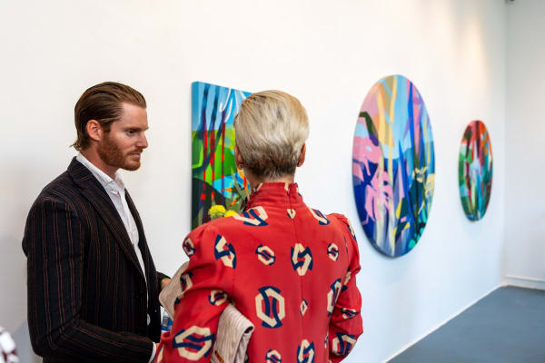 People inside Carousel Fine Art's Miami gallery space during Neill Wright's exhibition "Where the Light Gets In."