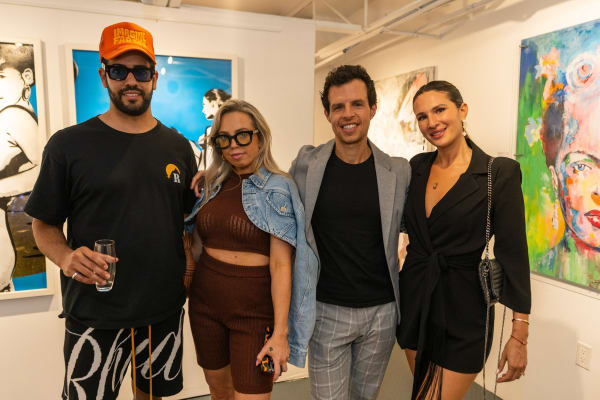 People posing for photo inside Carousel Fine Art's Miami gallery space during Neill Wright's exhibition "Where the Light Gets In."