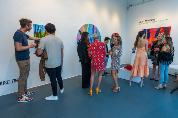 People inside Carousel Fine Art's Miami gallery space during Neill Wright's exhibition "Where the Light Gets In."