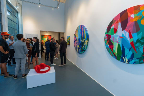People inside Carousel Fine Art's Miami gallery space during Neill Wright's exhibition "Where the Light Gets In."