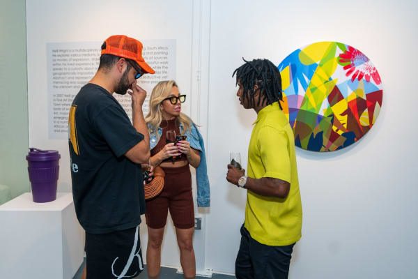 People inside Carousel Fine Art's Miami gallery space during Neill Wright's exhibition "Where the Light Gets In."