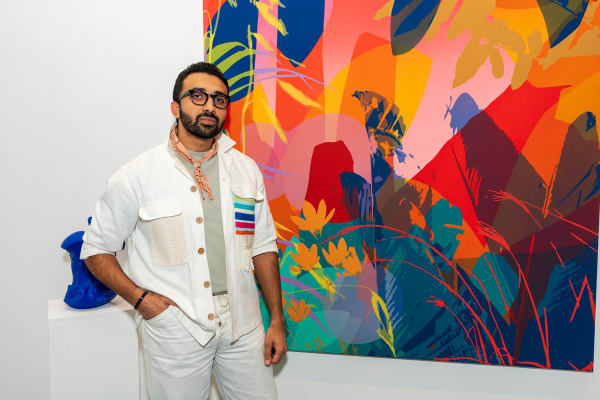 Man in front of painting by Eric Alfaro displayed inside Carousel Fine Art's Miami gallery space during Neill Wright's exhibition "Where the Light Gets In."