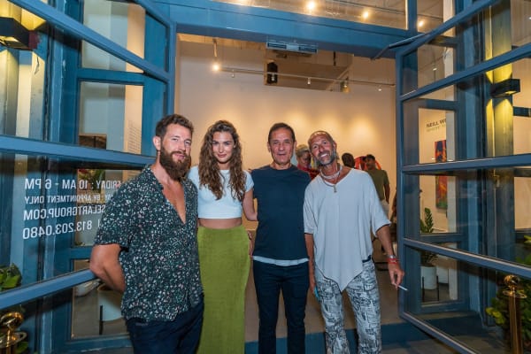 People posing outside of Carousel Fine Art's Miami gallery space during Neill Wright's exhibition "Where the Light Gets In."
