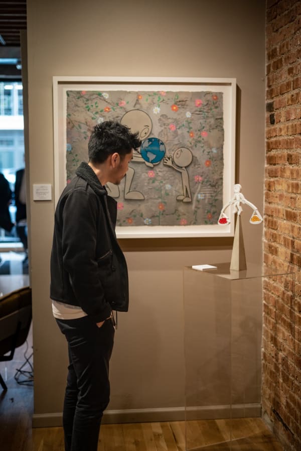 Man staring at paintings and sculpture in Carousel Fine Art's Chicago gallery space during the Chicago Grand Opening.