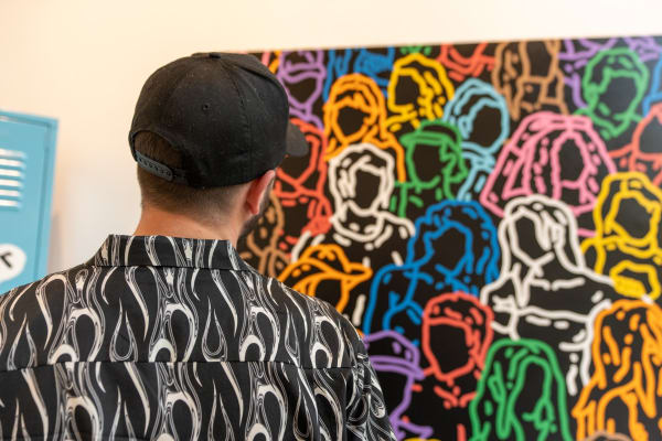 Artist Chance Cooper in front of his hanging artwork at Carousel Fine Art's gallery space in Miami, FL during Chance Cooper's Spotlight Exhibition, "Between Me and You."