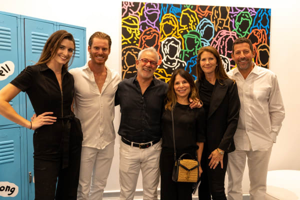 People posing in front of painting at Carousel Fine Art's gallery space in Miami, FL during Chance Cooper's Spotlight Exhibition, "Between Me and You."