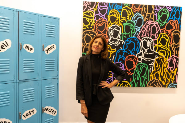 Woman posing at Carousel Fine Art's gallery space in Miami, FL during Chance Cooper's Spotlight Exhibition, "Between Me and You."