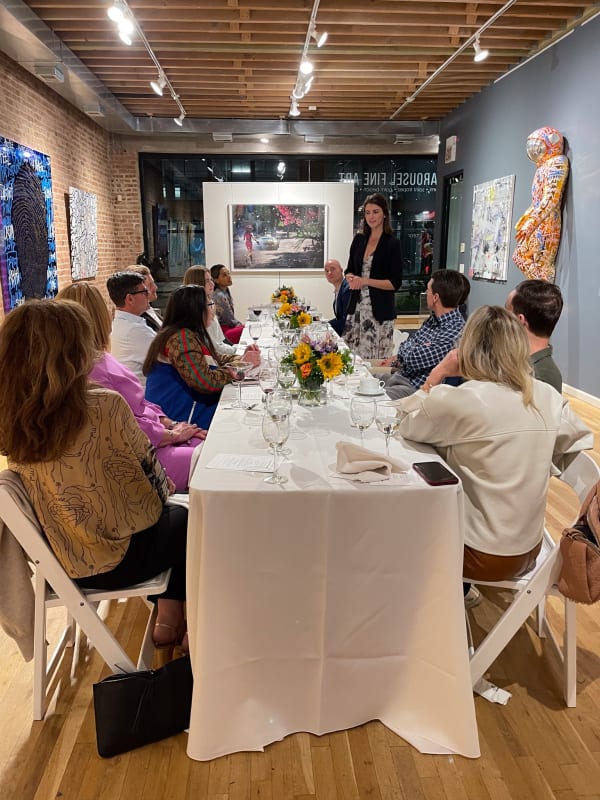 People sitting around decorated table for Collector's Dinner at Carousel Fine Art's gallery space in Chicago.