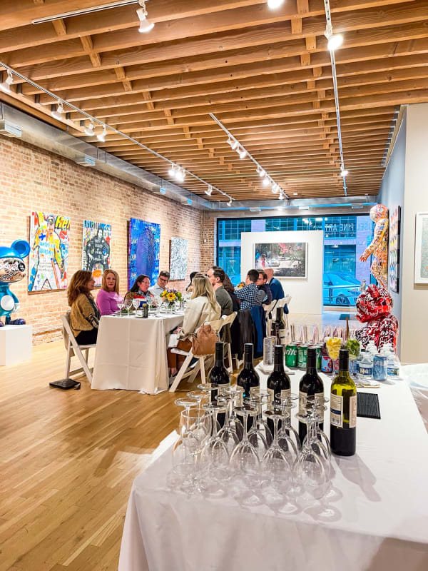 People sitting around table for Collector's Dinner at Carousel Fine Art's gallery space in Chicago.