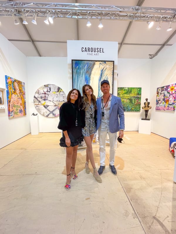 People posing in front of Carousel Fine Art's gallery both at the Hampton's Art Market, 2021.