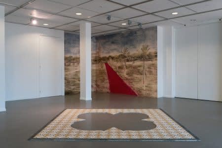 ‘The Karachi Star’, Cement Mosaic Tiles, 306.5 x 306.5 x 1.6 cms, 2022, with ‘Red Carpet’ (in the background), Abraded Inkjet printed on Hewlett Packard, Standard Smooth Wallpaper, 175 gsm, 326 h x 620 cms, 2022 © Huma Mulji