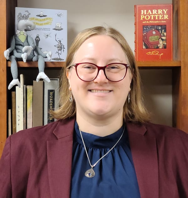 Image of Shannon K. Struble in front of a shelf of books