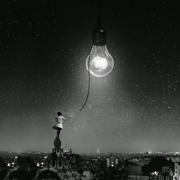black and white photograph of girl on a roof holding a chain attached to a lightbulb with the moon inside and starry sky.