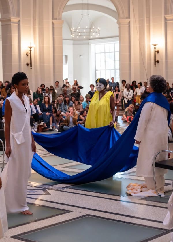 “A Mother’s Rivers of Tears,” performed on Sept. 16 at the Brooklyn Museum, honored the victims of police and vigilante violence and their mothers. Campos-Pons (in yellow) was joined by an ensemble of musicians and performers including LaTasha N. Nevada Diggs (right), Peyton Brown (left) and Dell Hamilton (left, slightly obscured). Naeem Douglas