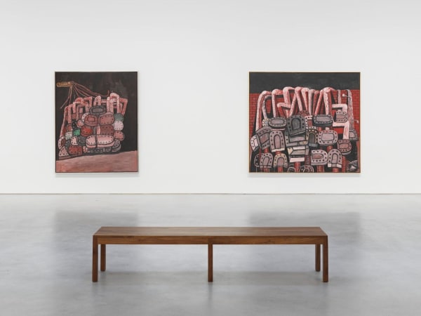 A museum gallery installation photograph of a brown wooden bench before two abstract oil paintings by Philip Guston hang on the wall rendered in shades of black, red and pink